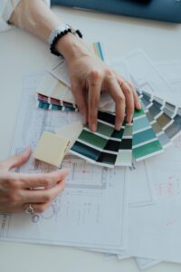 Interior designer evaluating color swatches and blueprints in the workspace.